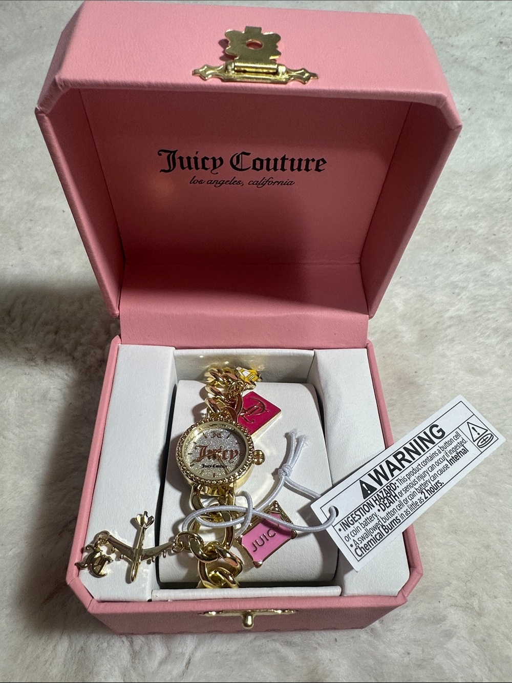 Juicy Couture gold-toned charm watch featuring a glittery face